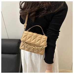 Sac bandoulière beige matelassé avec chaîne épaisse et bandoulière sur un mannequin