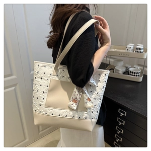 Detail of off-white quilted shoulder bag with decorative scarf and PU leather trim