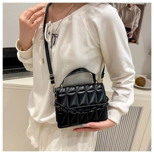Détail du sac bandoulière matelassé noir avec chaîne épaisse et finitions dorées