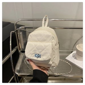 Detail of white quilted leather mini backpack with silver twist lock and chain strap