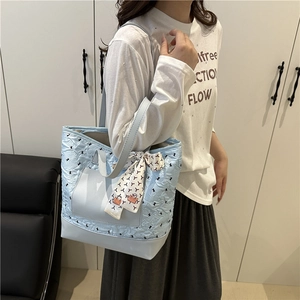 Light blue quilted shoulder bag with floral print and decorative silk scarf for women