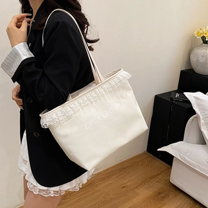 Chic off-white faux leather tote bag with elegant lace trim and artistic lettering
