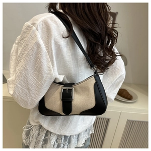 Detail of canvas and black leather hobo bag with silver buckle and woven texture