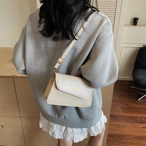 Chic cream patchwork shoulder bag with woven texture and gold hardware for 2025