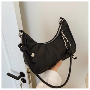 Detail of black nylon crescent bag with silver chain and unique knot strap design