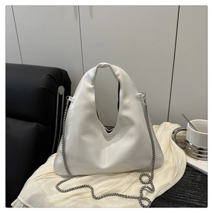 Close-up of minimalist white leather Hobo bag with stylish silver metal chain detail