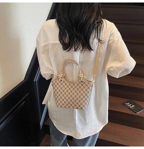 Sac seau tendance avec motif monogramme contrasté porté par un mannequin en intérieur