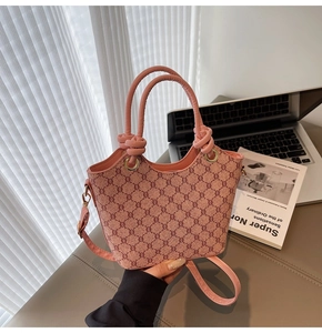 Détail du sac seau rose à monogramme avec poignée nouée et finitions dorées