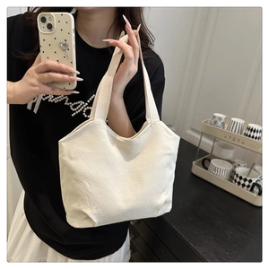 Detail view of white canvas tote bag with thick handles and textured durable fabric