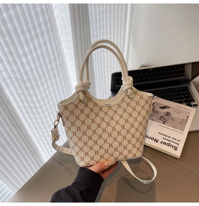 Détails de la poignée nouée et du motif monogramme rétro sur un sac crème