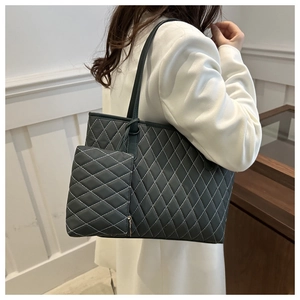 Sac cabas matelassé avec pochette assortie, porté à l'épaule dans une pièce sobre