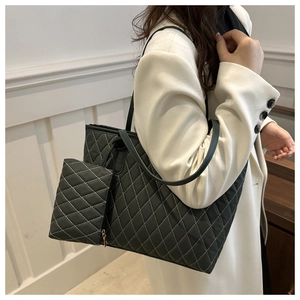 Détail du sac cabas matelassé noir avec pochette assortie et surpiqûres en losange