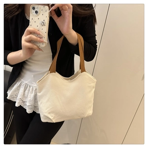 Detail showing white canvas tote bag with brown straps and minimalist japanese design