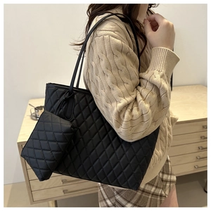 Détail du sac cabas matelassé noir avec pochette assortie, texture et grande capacité