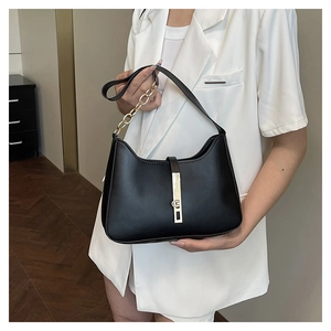 Détail du sac hobo noir en cuir avec boucle en métal doré et bandoulière chaîne épaisse