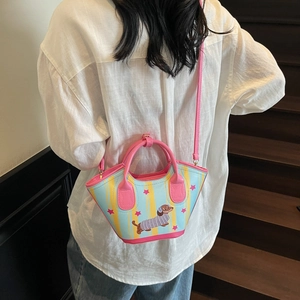 Sac seau à rayures teckel de niche porté en bandoulière sur mannequin, décor lumineux