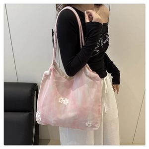 Detail of pink tie-dye tote bag featuring 3D white floral appliques and long shoulder straps