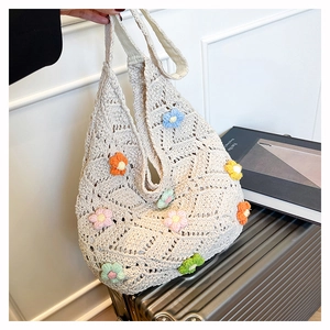 Detail of hand-crocheted beige tote bag with colorful 3D knitted flower decorations