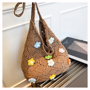 Close-up of handmade brown crochet bag with colorful 3D knitted flower patterns