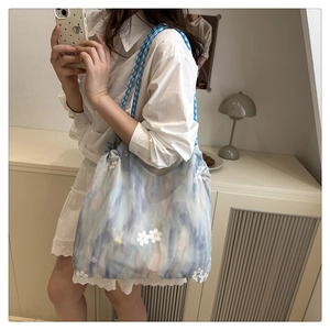Detail of blue marble tote bag with 3D daisy embroidery and woven rope handle