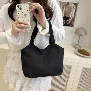 Minimalist black canvas tote bag for women featuring a casual solid color design and shoulder straps