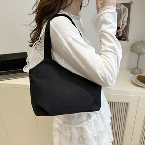 Minimalist black canvas tote bag for women showing a stylish shoulder design for daily use