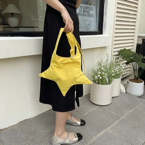 Sac fourre-tout jaune vif en forme d'étoile porté en bandoulière pour un look streetwear