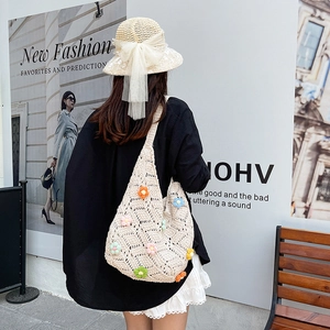 Minimalist cream crochet tote bag with colorful floral embroidery in a casual street setting