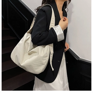 Detail of a large cream tote bag with natural pleated texture for a minimalist fashion look