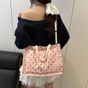 Pink corduroy tote bag with red hearts featuring dual front pockets and shoulder straps
