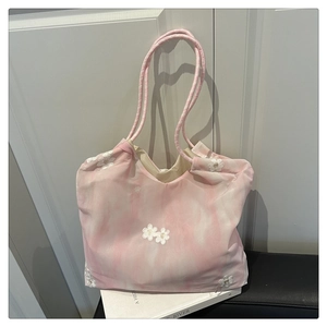 Detail of pink and white textured tote bag with 3D floral appliqués and woven rope handle