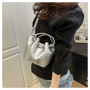 Detail of silver bucket bag showing knot handle and SUNNY BAG FASHION lettering
