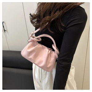 Detail of pink pleated leather bag featuring knotted handle and soft cloud shape