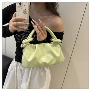 Detail of pistachio green leather handbag with pleated design and cylindrical handle