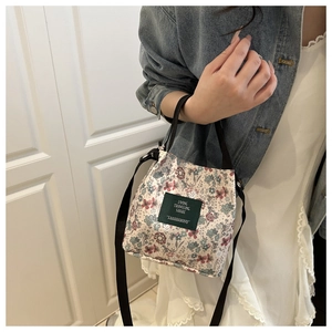 Floral print bucket bag shown with denim jacket for a trendy summer casual look