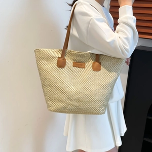 Handmade straw tote bag with brown leather handles and fashion patch for summer beach trips