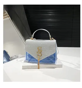 Détail du sac en PVC bleu transparent avec rabat à paillettes argentées et gland