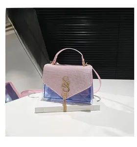 Détail du rabat à paillettes roses et boucle dorée en S sur un sac en PVC violet