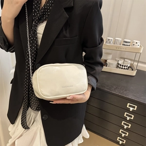 Sac bandoulière minimaliste en cuir blanc avec chaîne argentée et lettrage décoratif