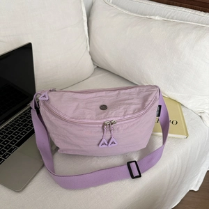 Détail du sac croissant en nylon lilas montrant la texture plissée et l'étiquette logo