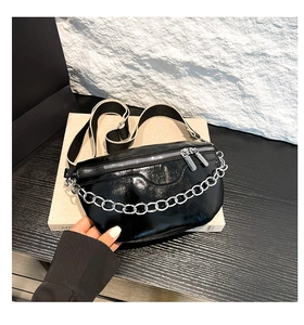 Detail der schwarzen Lackleder-Gürteltasche mit Silberkette und Doppelreißverschluss