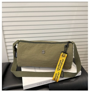 Detail der armeegrünen Nylon-Zylindertasche mit gelbem Schriftband und Metall-Logo