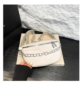 Detailansicht der weißen Gürteltasche mit Silberkette und eingraviertem FASHION Schriftzug