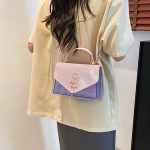 Sac bandoulière violet chic avec strass brillants et logo doré porté par un modèle