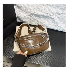 Detail der braunen Vintage-Satteltasche mit silberner Metallkette und Ölwachs-PU-Leder