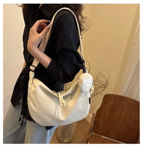 Lifestyle shot of an off-white nylon crescent bag with a round mini coin purse detail