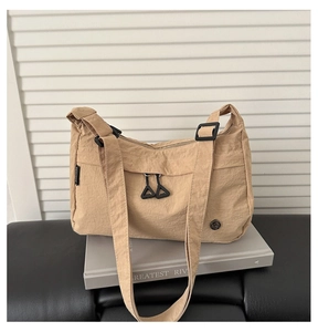 Detail of light khaki pleated nylon fabric texture on a large capacity crossbody bag