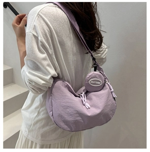 Detail of lavender nylon crescent bag with detachable coin purse worn by model