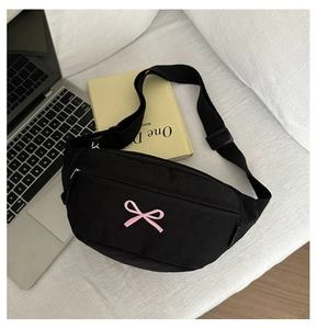 Detailansicht der schwarzen Nylontasche mit rosa Schleife und silbernem Reißverschluss