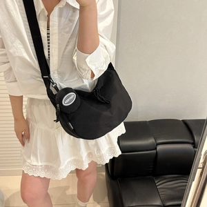 Minimalist black nylon crescent crossbody bag with adjustable strap and small coin purse